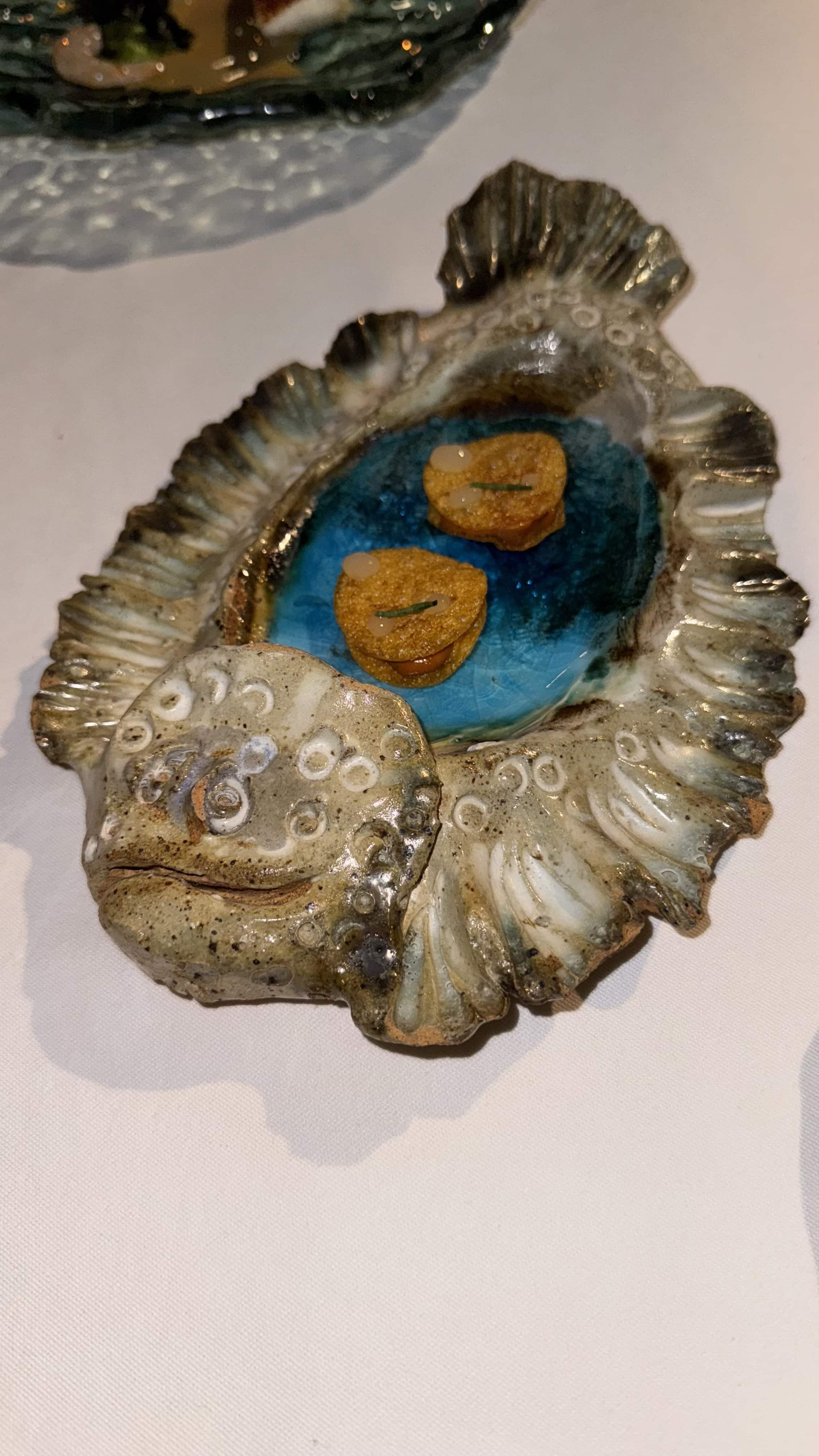 A plate shaped like a fish with two crackers on it.
