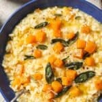 Creamy butternut squash risotto served in a blue bowl, topped with golden roasted squash cubes, crispy sage leaves, and grated parmesan. A cozy fall dinner idea with rich, velvety arborio rice and seasonal flavors.