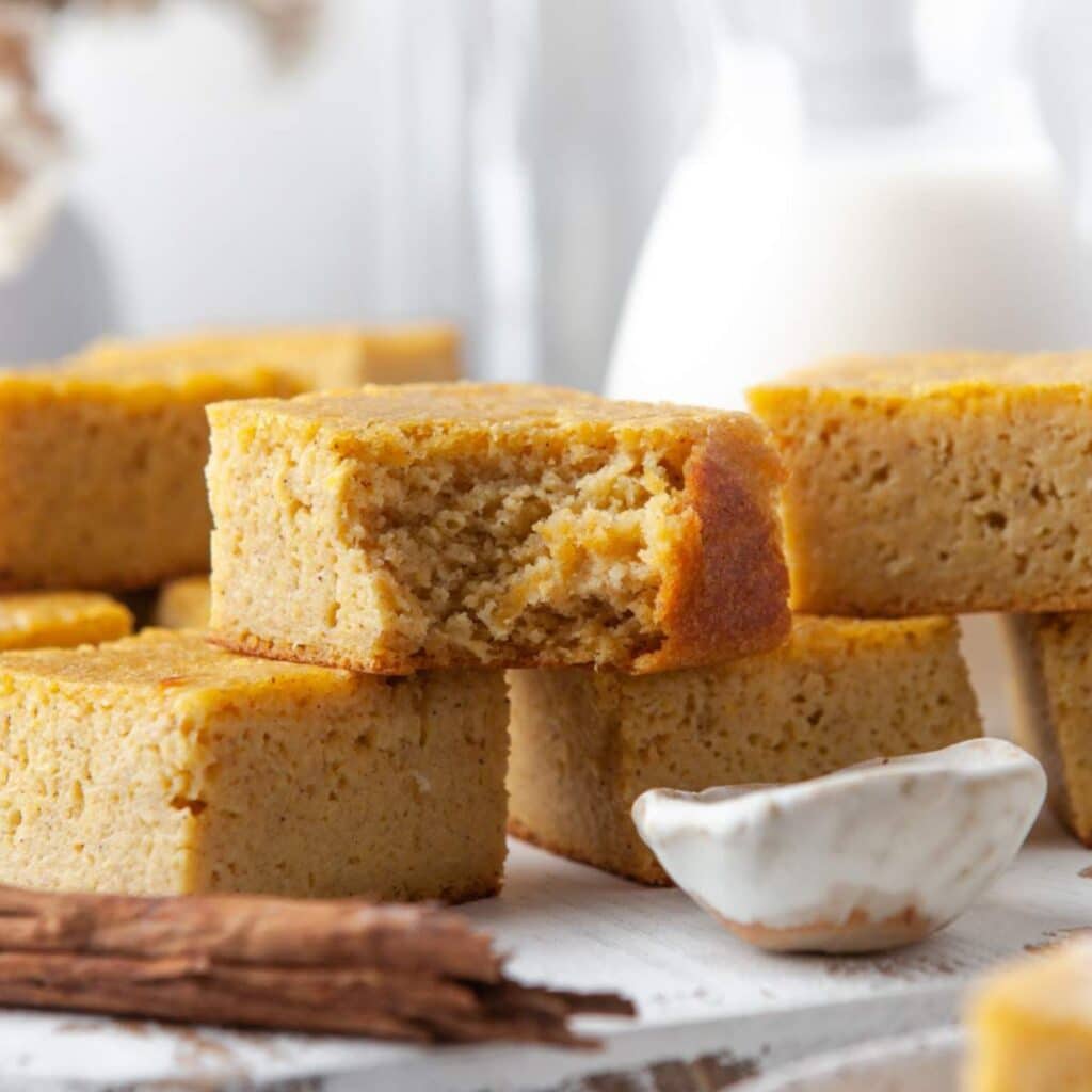 Cornbread squares, one with a bite taken.