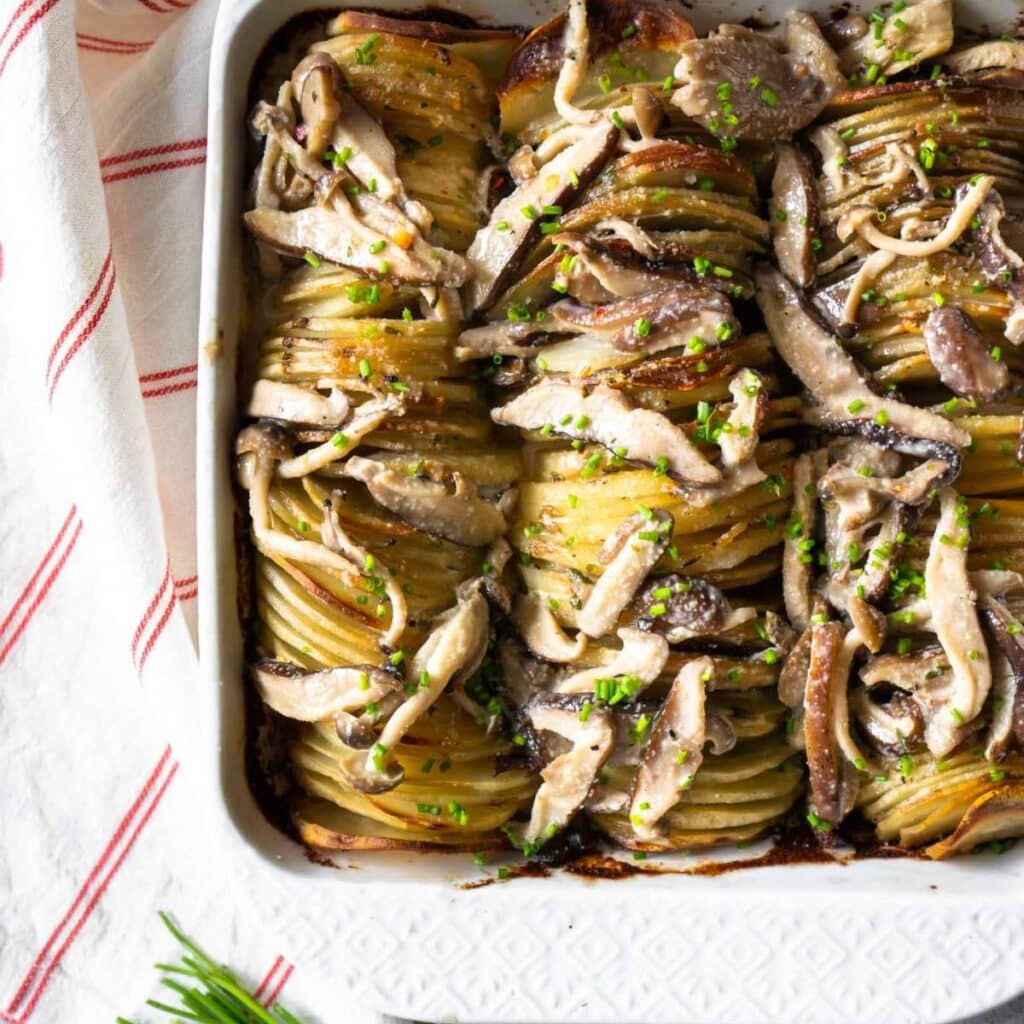 Hasselback potatoes topped with mushrooms.