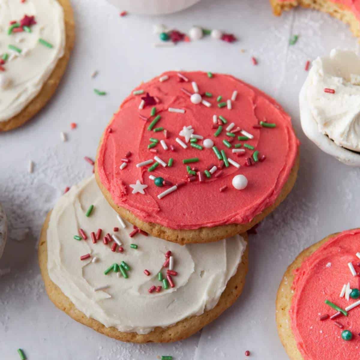 Red and white holiday sugar cookies with a glass of milk.