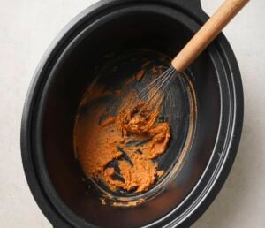 Stirring butter with flour and spices in a crockpot.