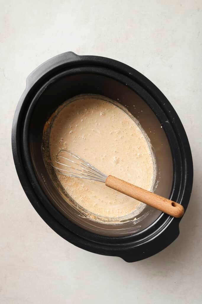 Whisking the beer into the flour mixture in a slow cooker.