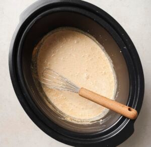 Whisking the beer into the flour mixture in a slow cooker.