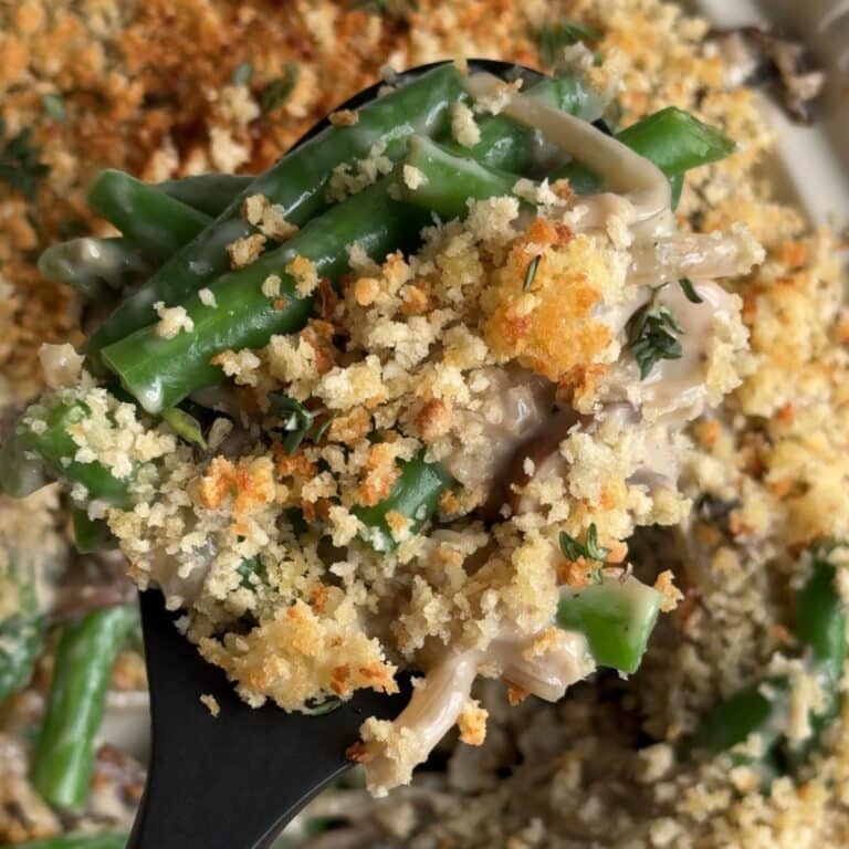 Green bean casserole with crispy panko on a serving spoon.