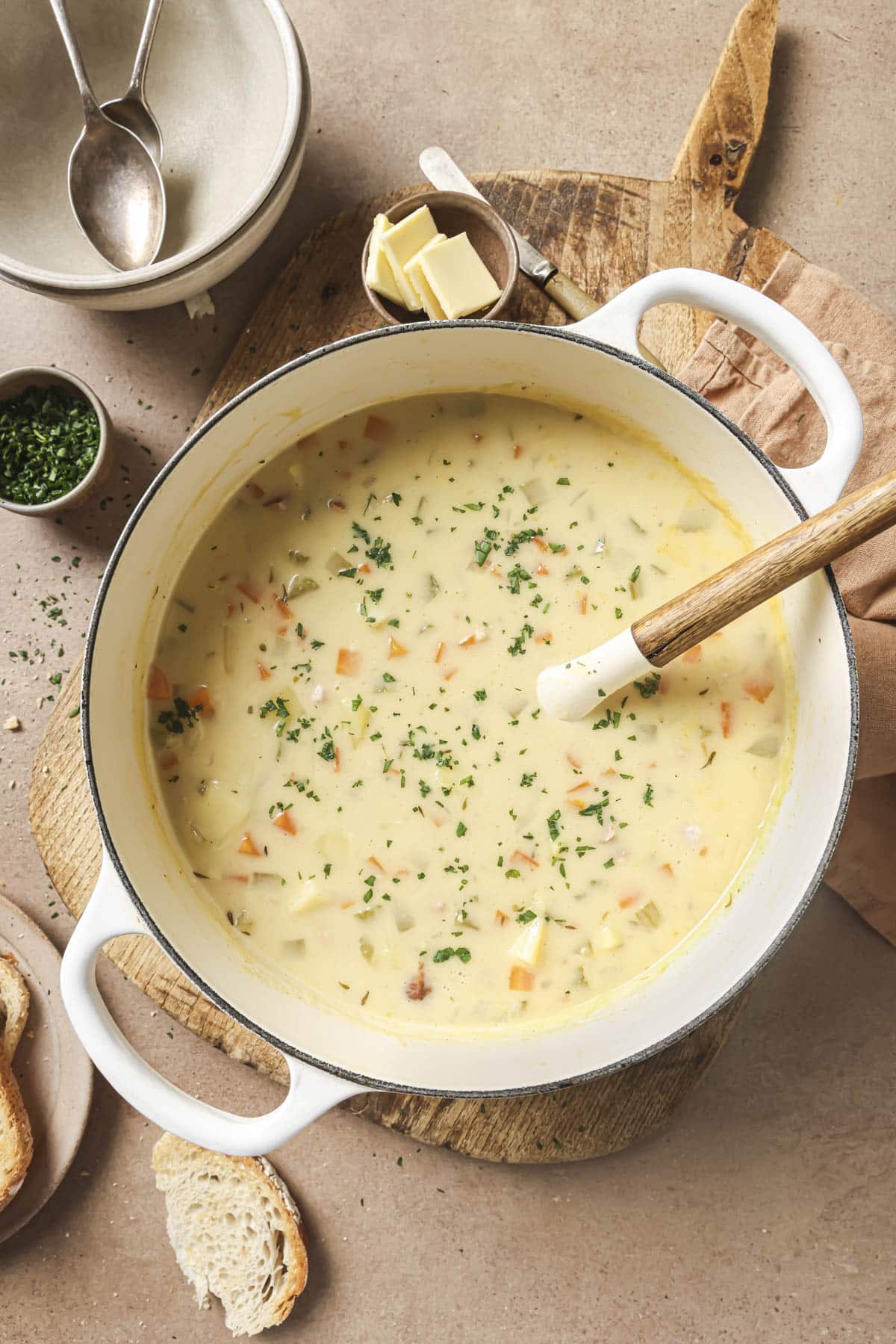 Stirring ham and potato soup in a large pot.