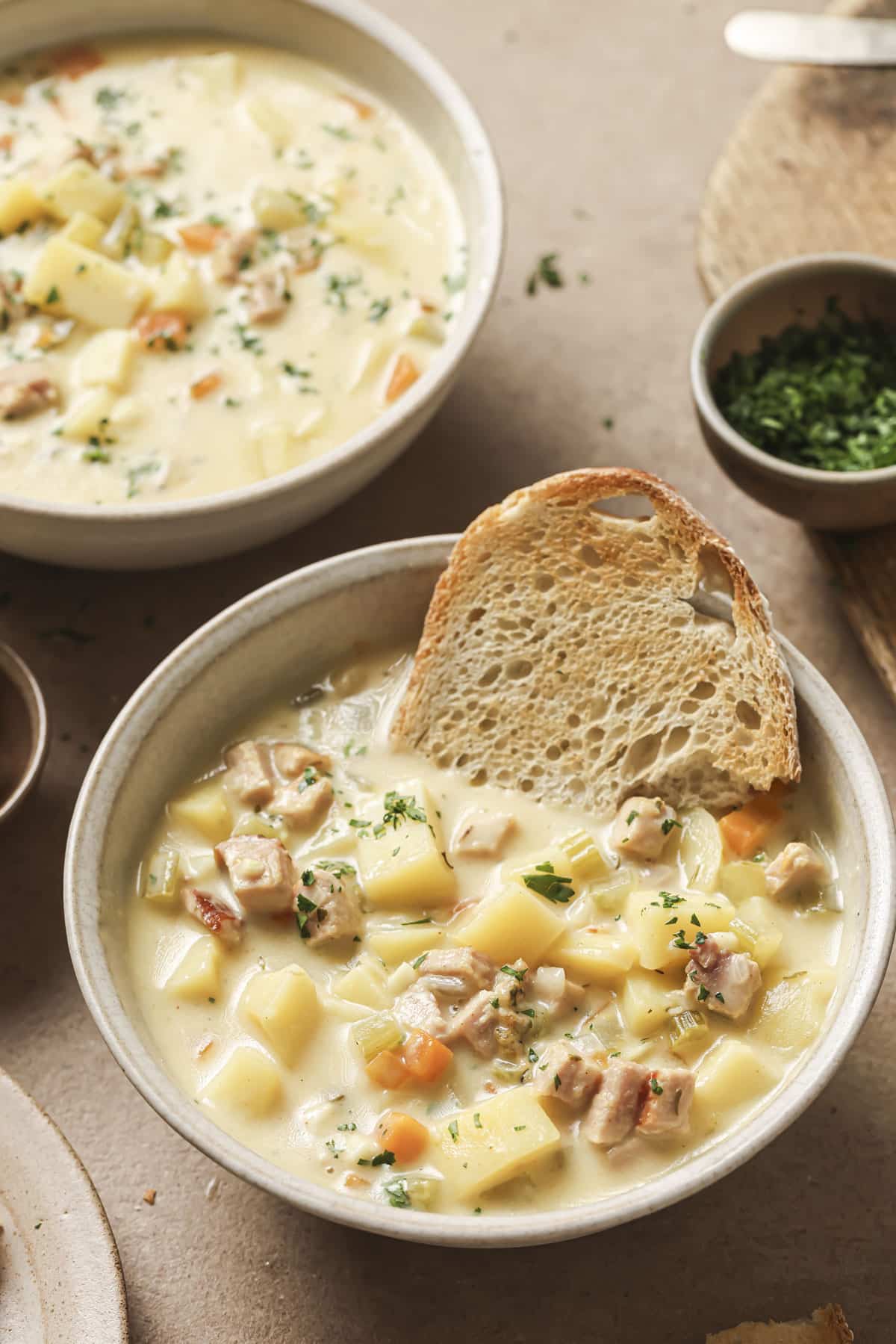Toasted bread in a bowl of ham and potato soup.