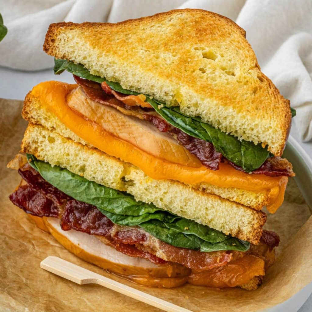 Two turkey sandwich halves stacked on top of each other.