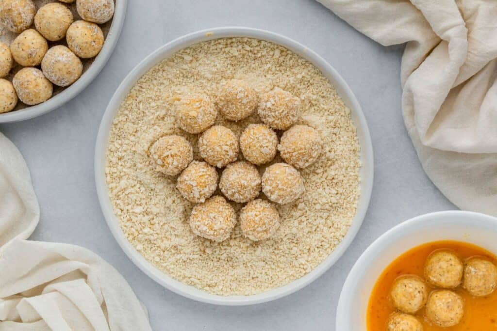 Coating balls of goat cheese in egg and panko.