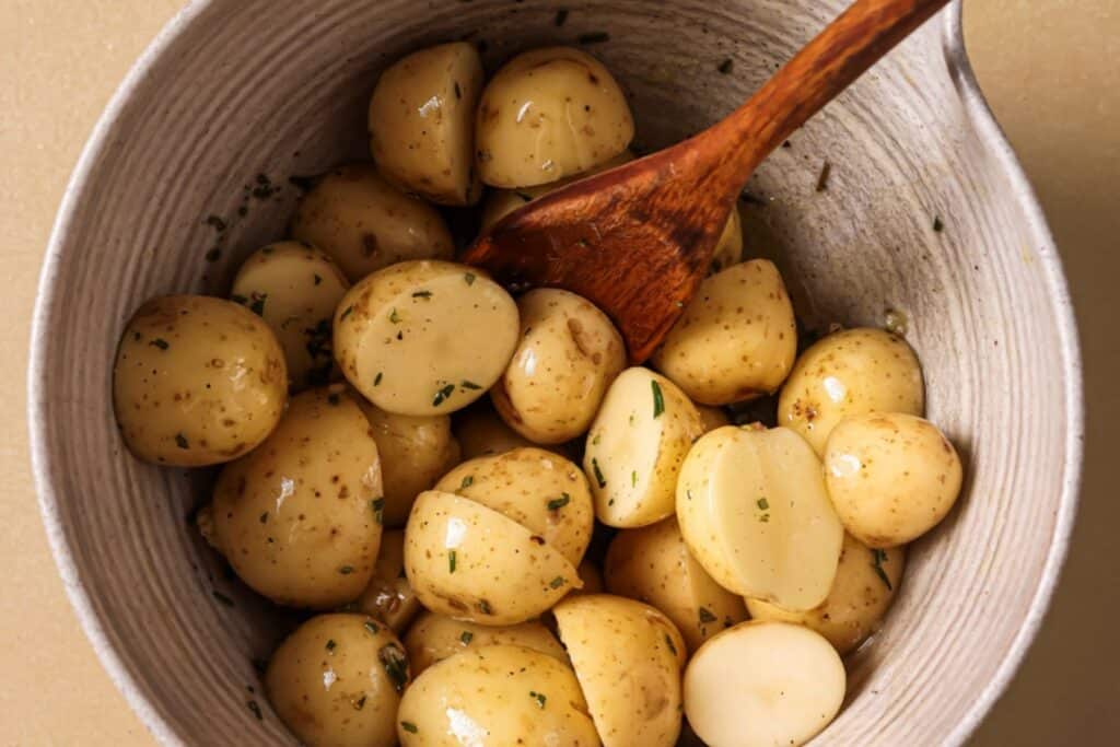 Tossing potatoes in oil and seasonings.