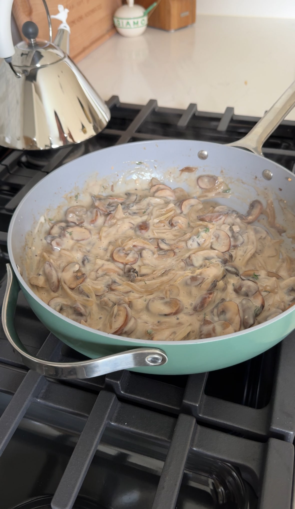 Creamy mushroom sauce cooking in a pan.