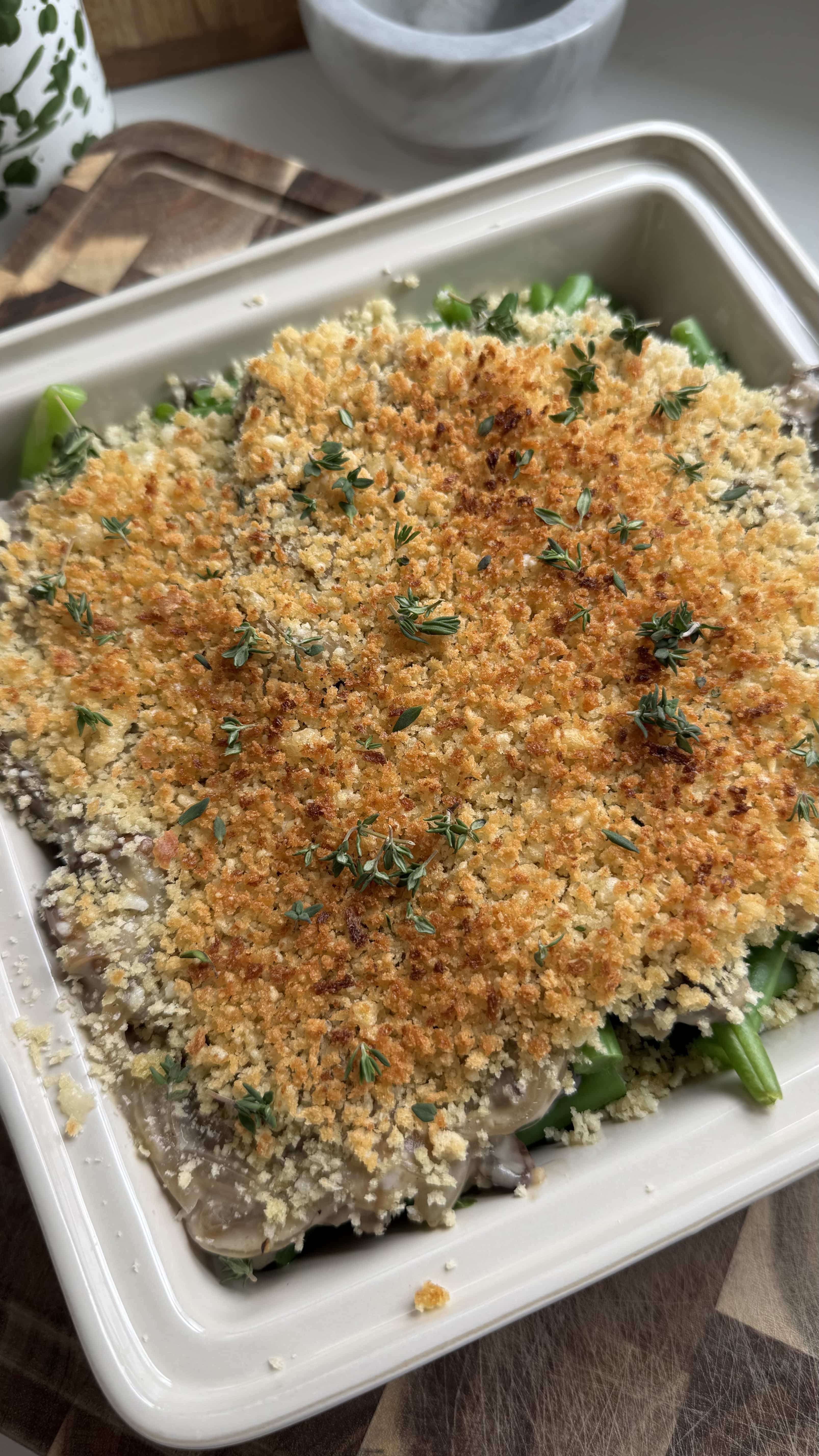 Green bean casserole with a crispy panko topping in a white baking dish.