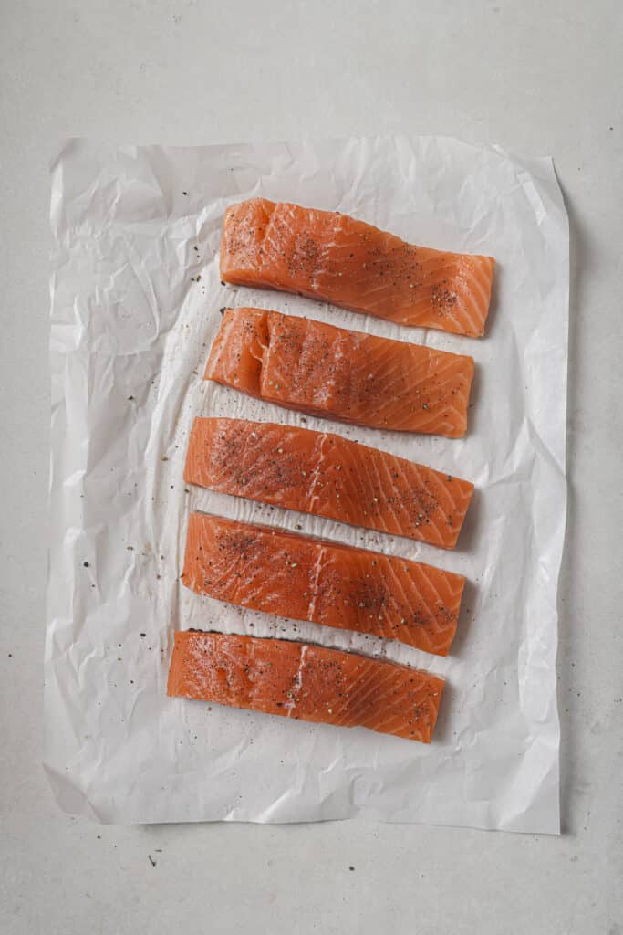 Seasoned salmon on parchment paper.