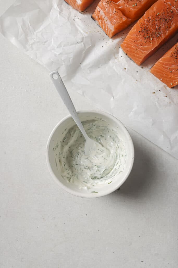 Stirring together mayo, herbs and lemon juice.