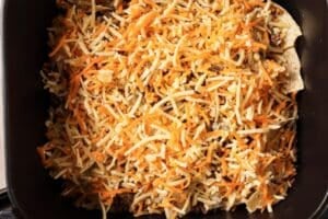 Adding cheese on top of tortilla chips.