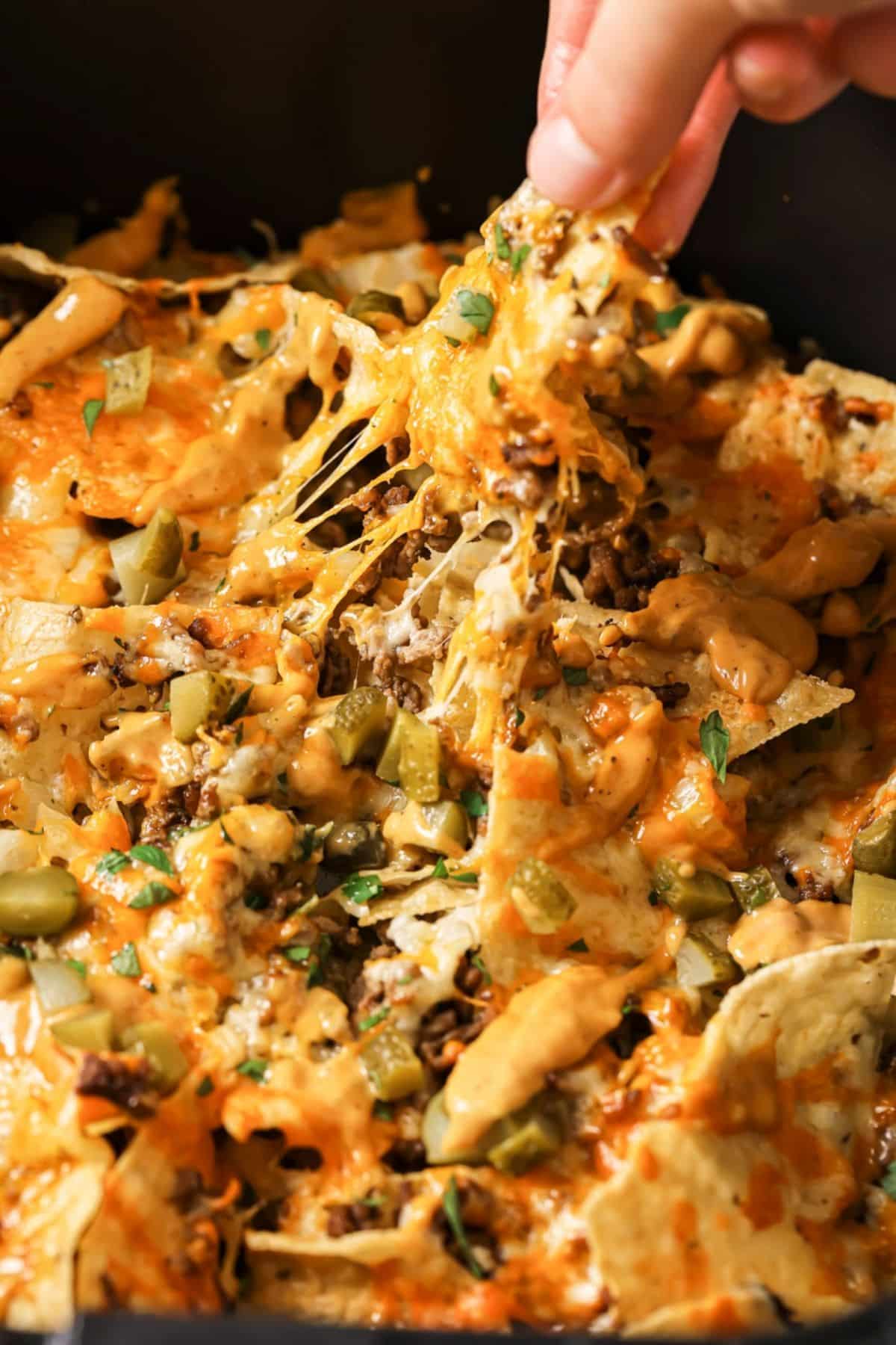 Picking up a chip from a plate of nachos.