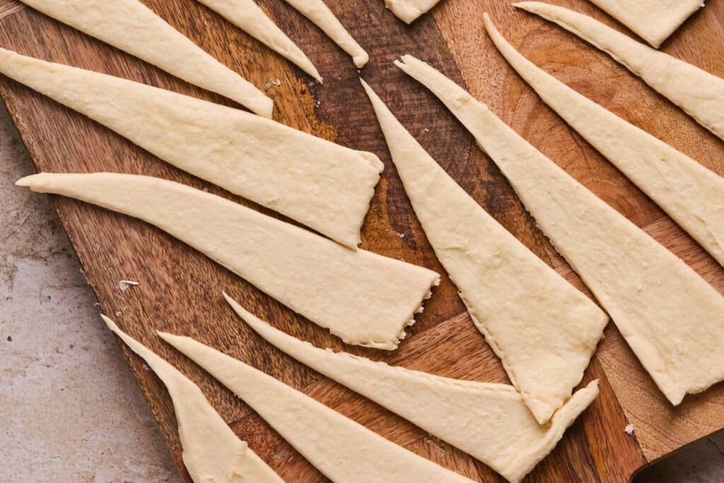 Pieces of crescent roll dough on a cutting board.