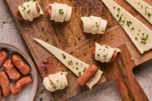 Wrapping little smokies in crescent roll dough.