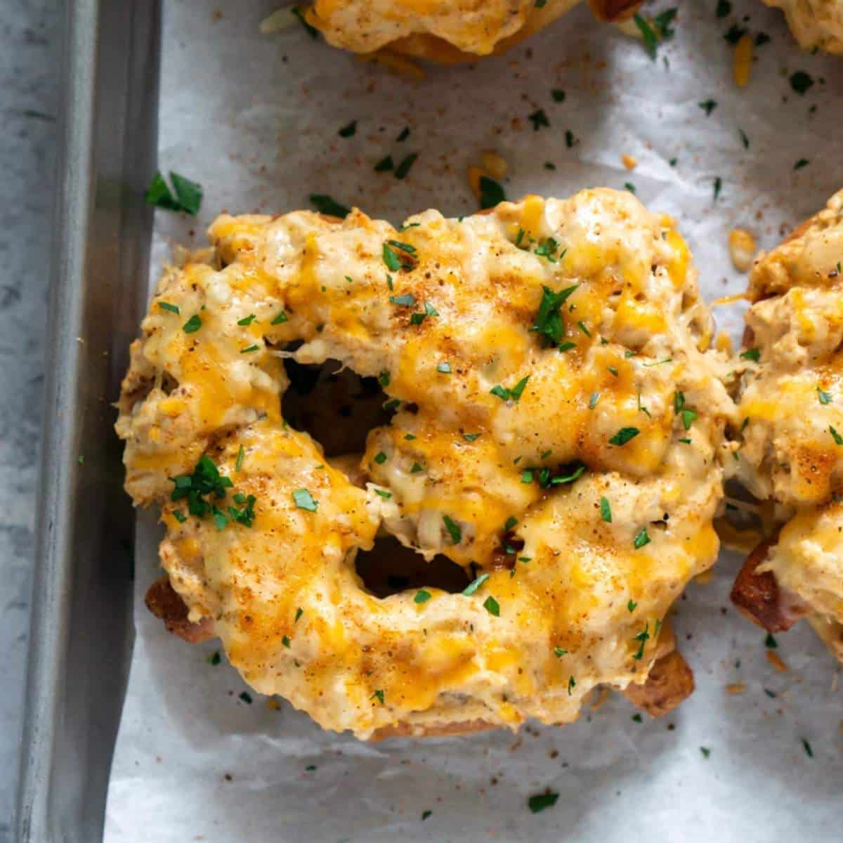 Soft pretzel topped with Maryland crab dip on a pan.