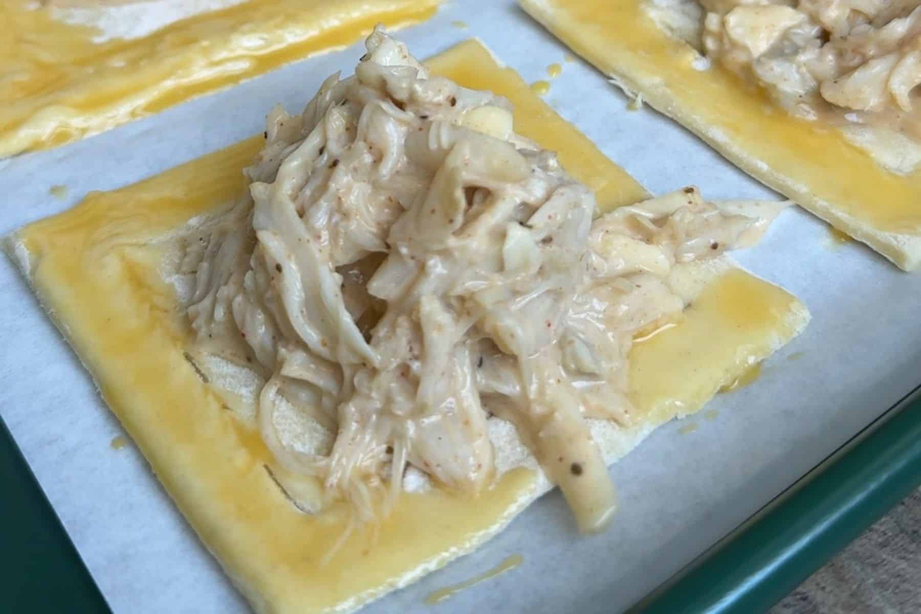 Crab filling on a pastry square.