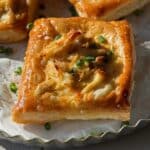 Crab puffs garnished with chives on a serving tray.