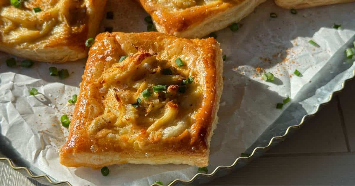 Crab puffs garnished with chives on a serving tray.