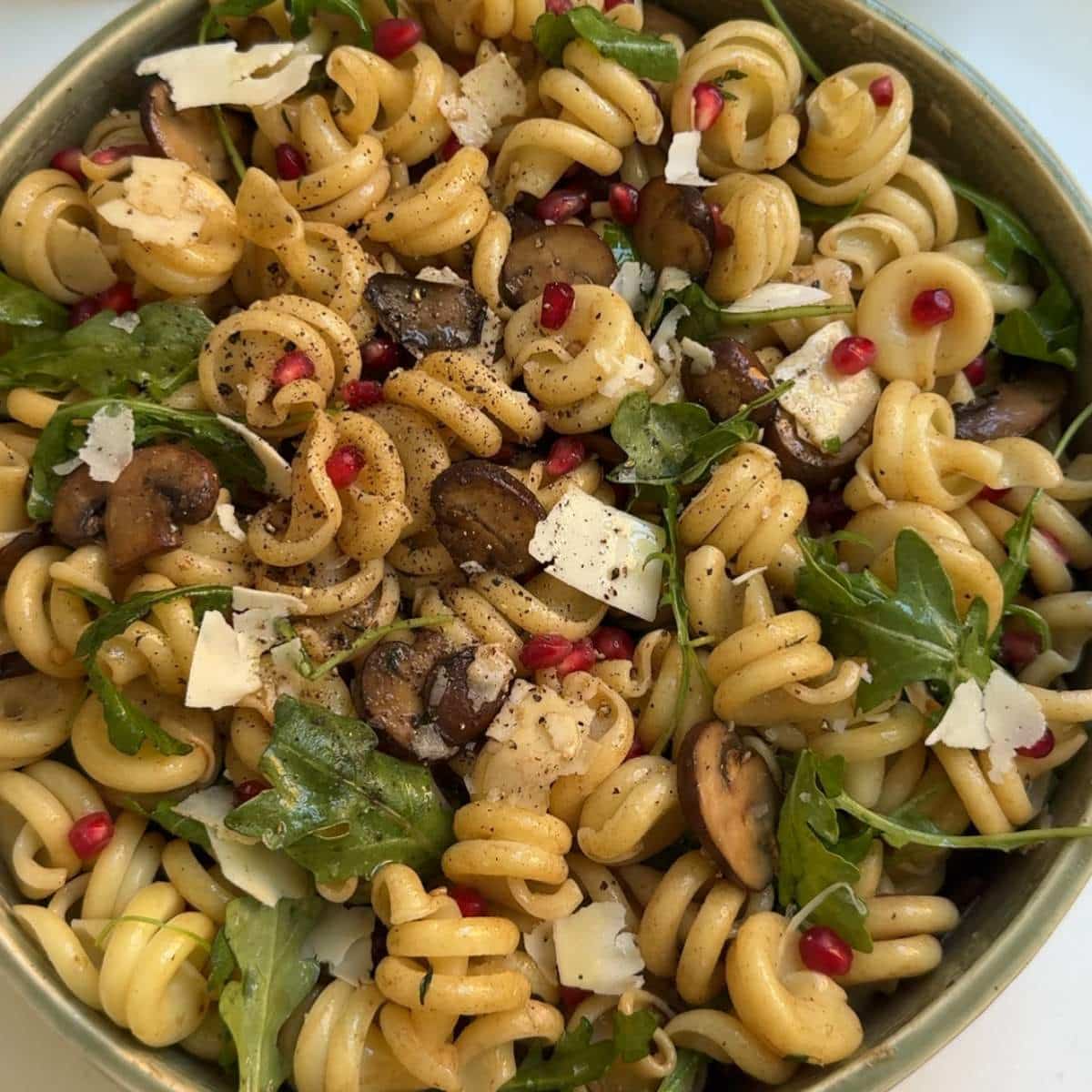 Mushroom pasta salad topped with pomegranate arils.