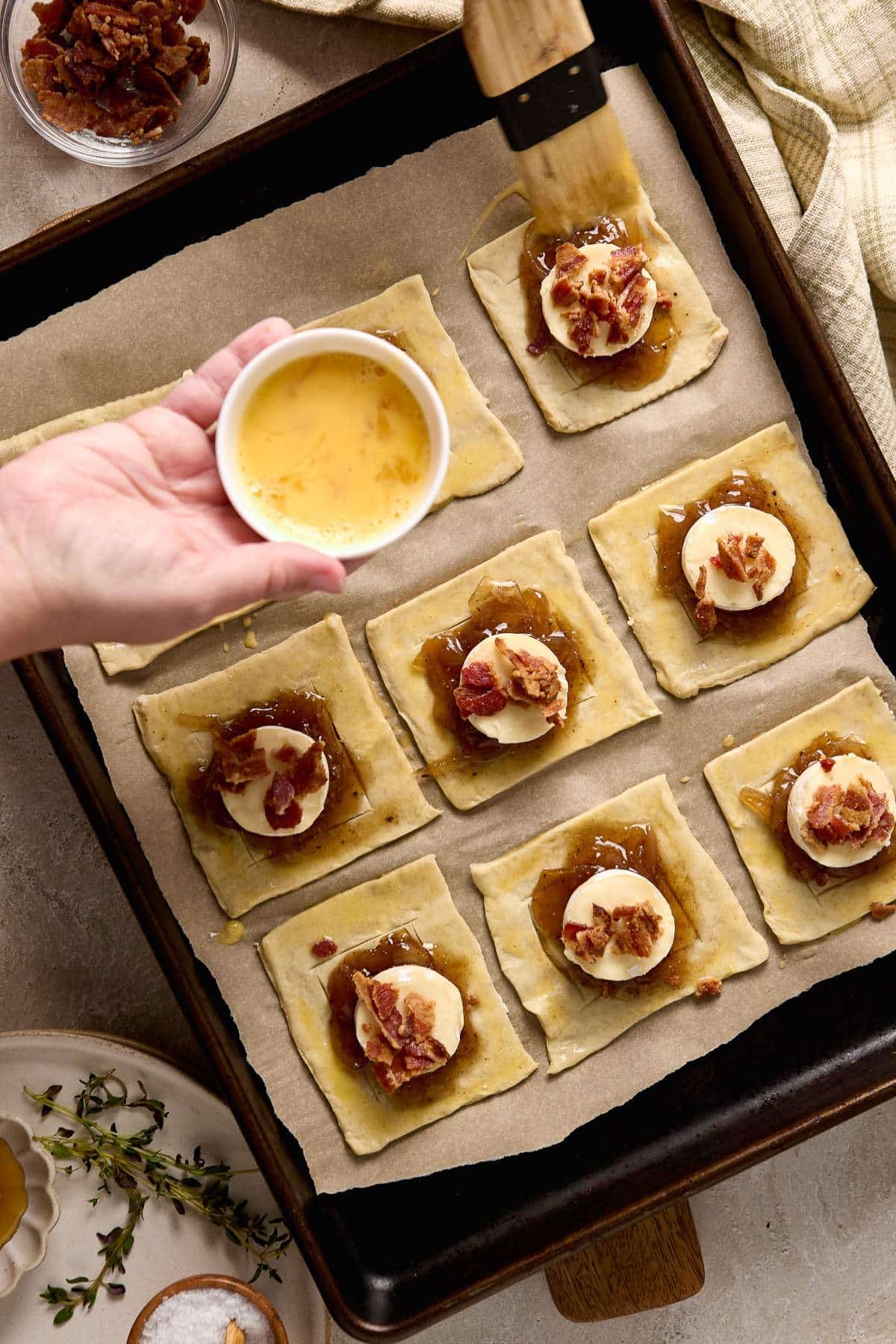 Brushing the edge of a puff pastry with egg wash.