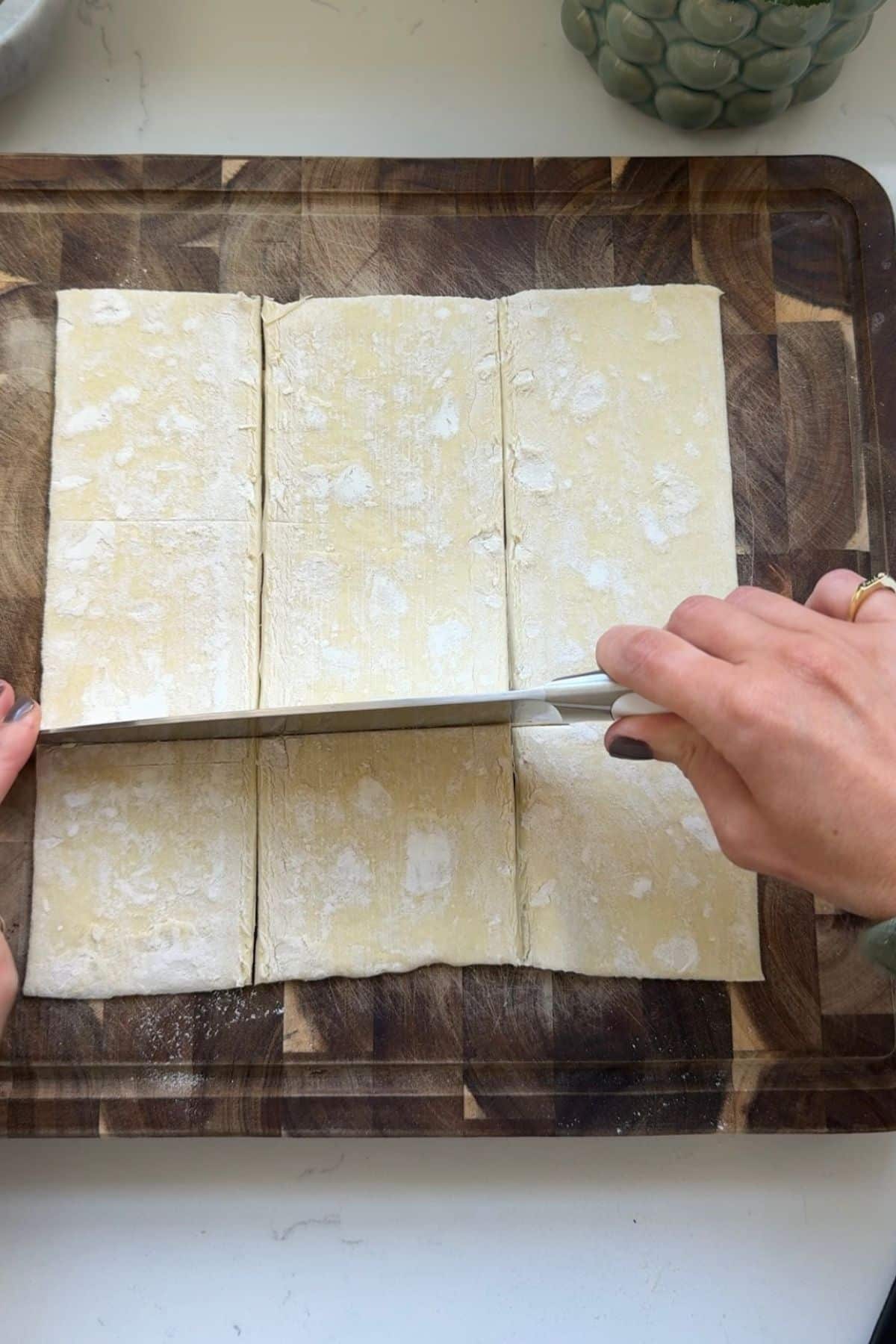 Cutting puff pastry dough into squares.
