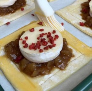 Brushing the edge of a puff pastry with egg wash.