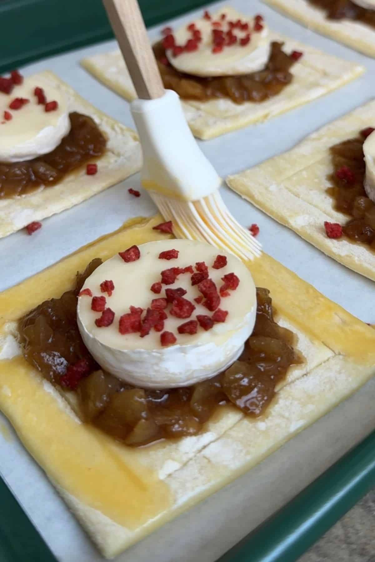 Brushing the edge of a puff pastry with egg wash.