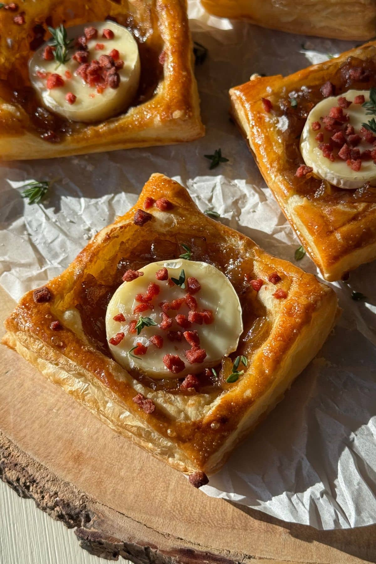 Baked puff pastry onion tarts topped with crumbled bacon.
