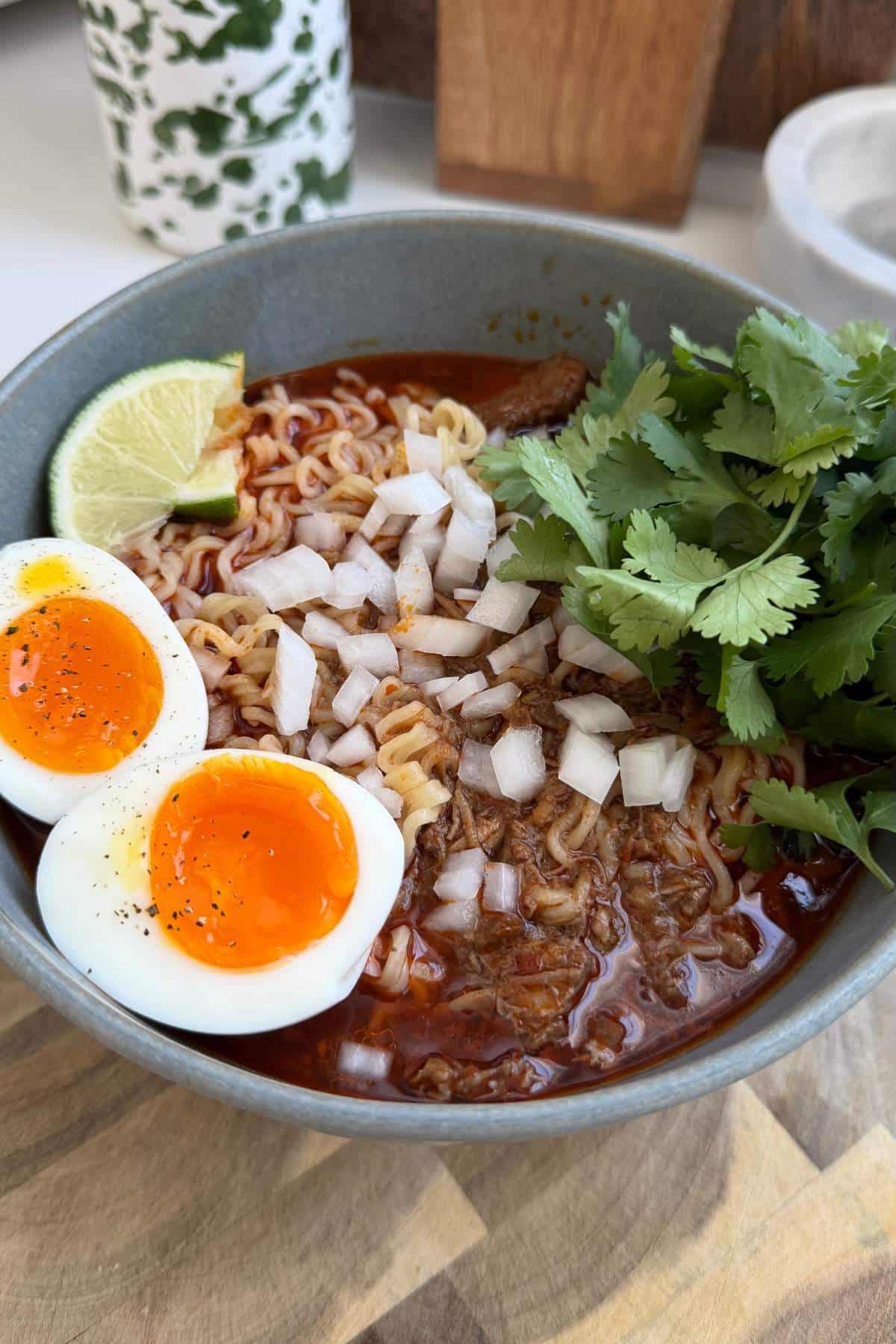 Birria Ramen served with a soft boiled egg, chopped onion and fresh cilantro.