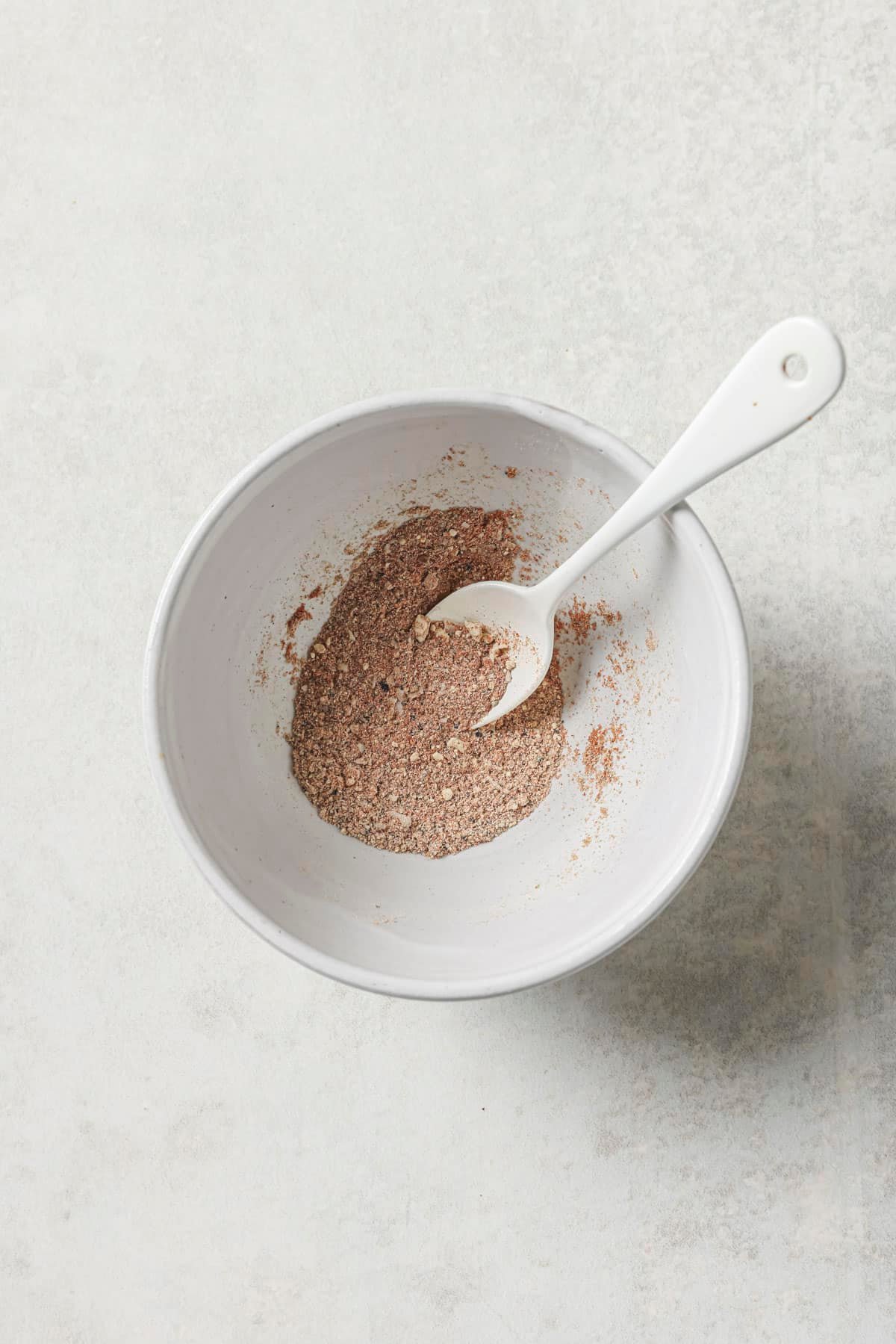 Stirring spices in a small white bowl.