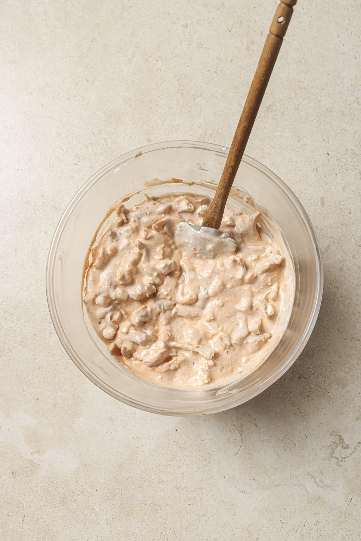 Stirring together cottage cheese with chicken, blue cheese and yogurt.