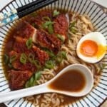 Gochujang Honey Chicken Ramen served in a bowl with a soft-boiled egg and chopsticks.