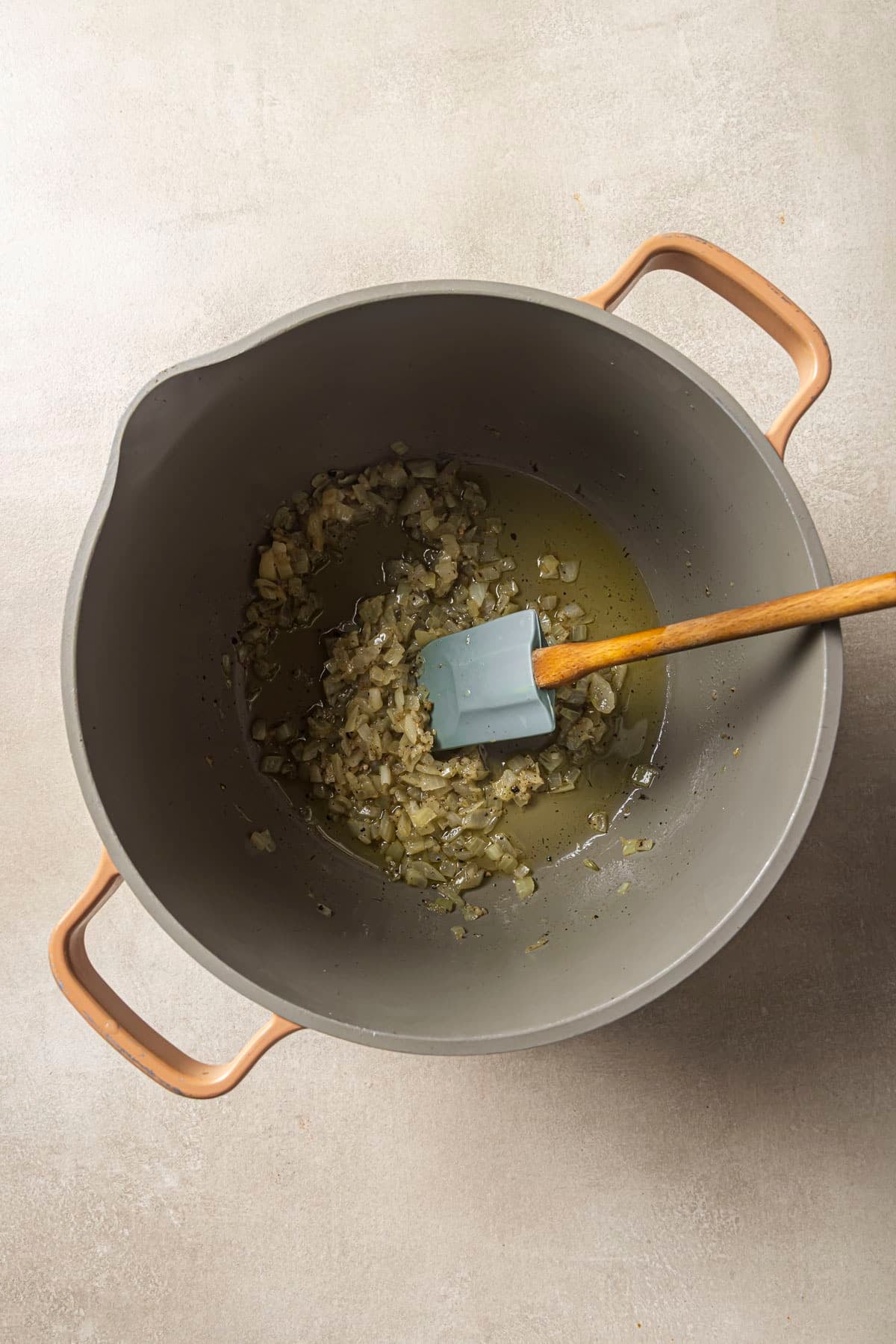 Sautéing onion and garlic in a large pot.