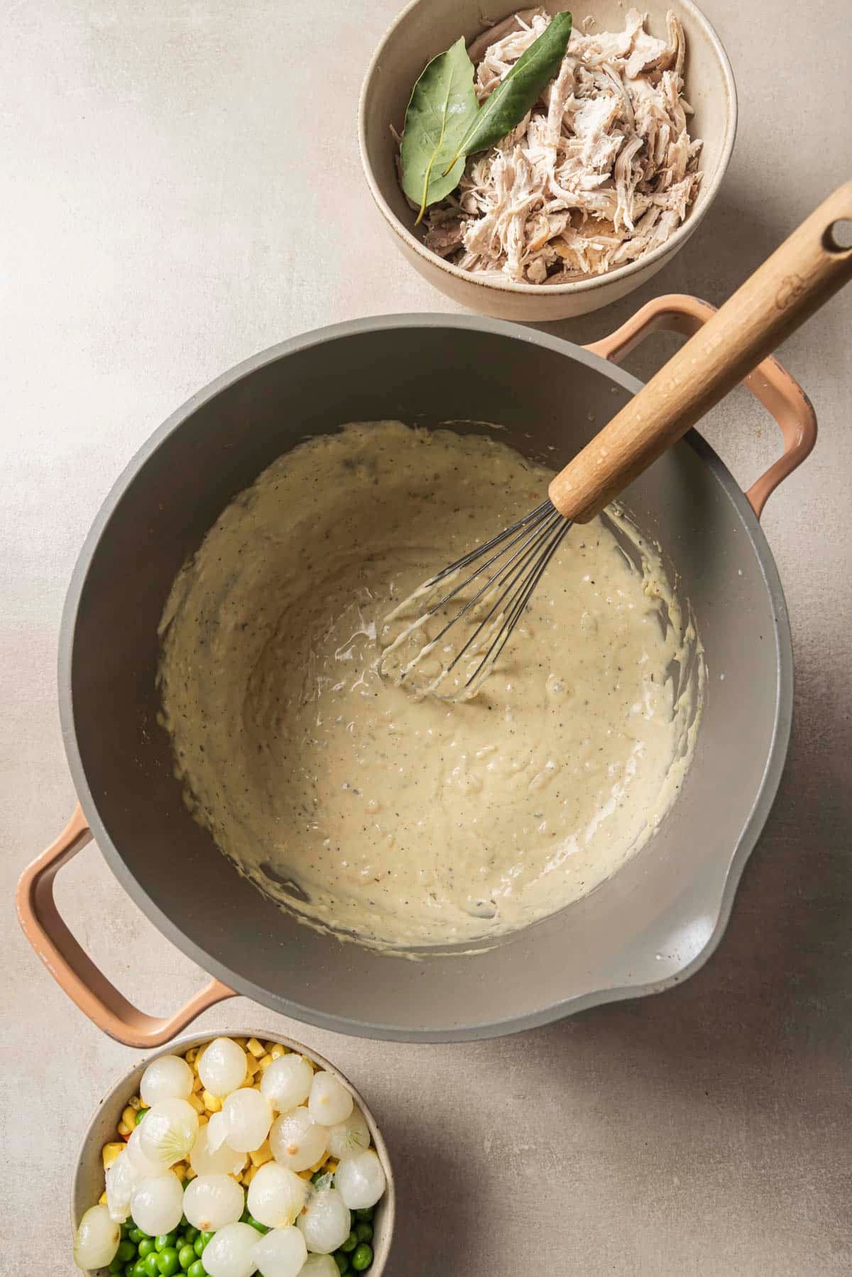 Whisking a creamy sauce in a large pot.