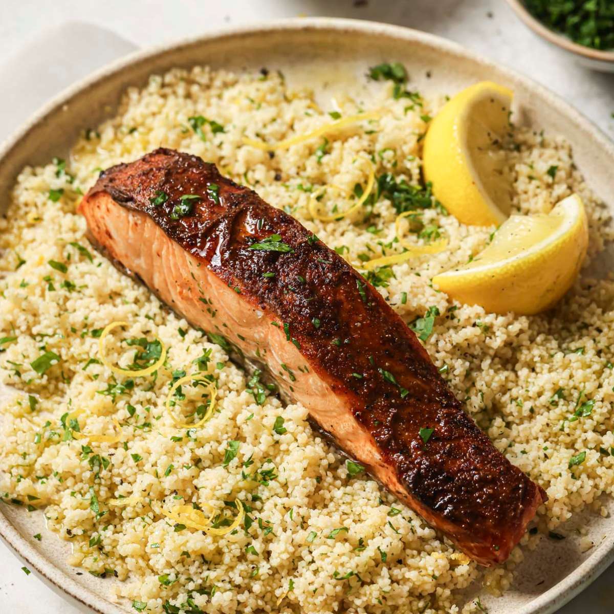 Air fryer salmon served on a plate over couscous.