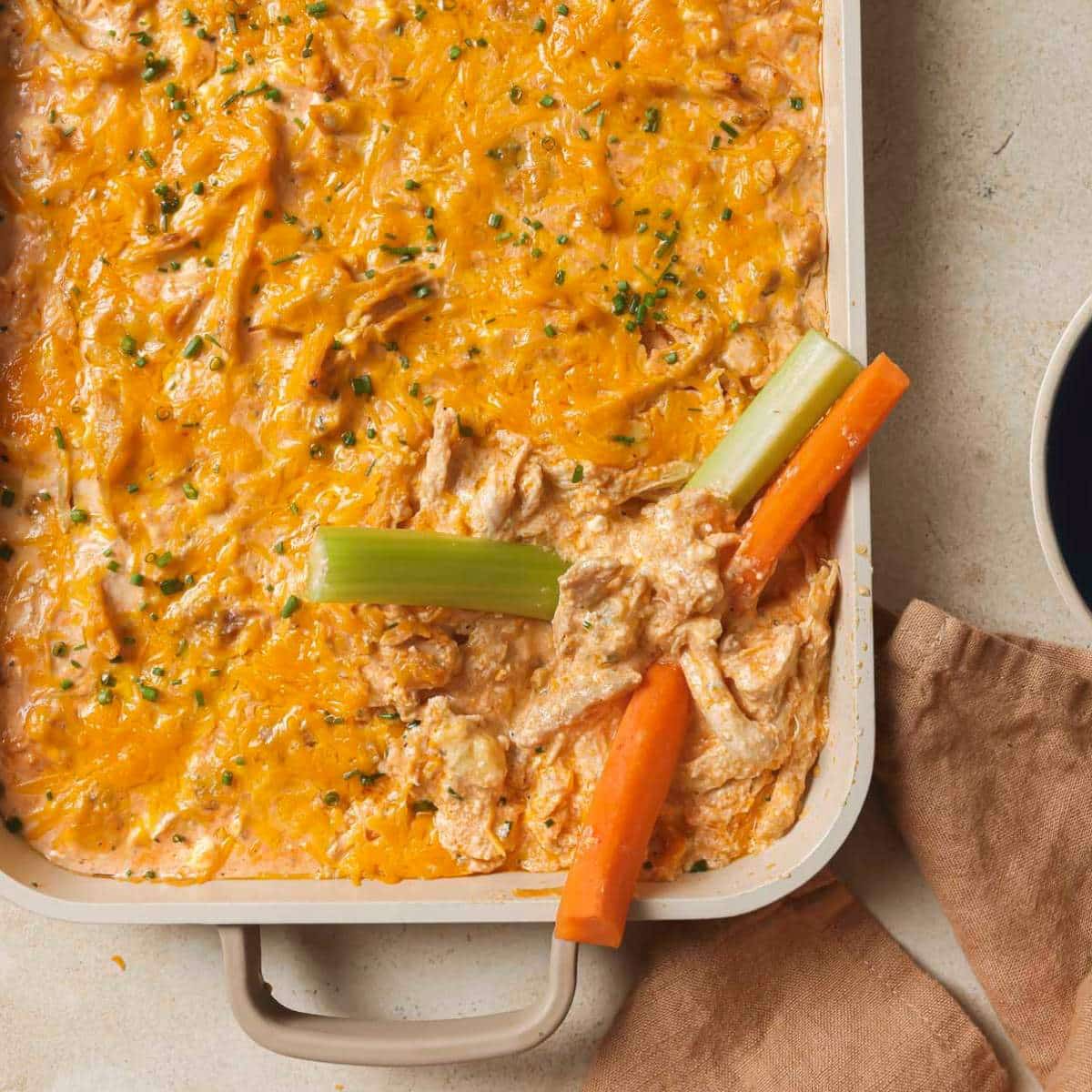 Carrots and celery sticks dipped in buffalo chicken dip.
