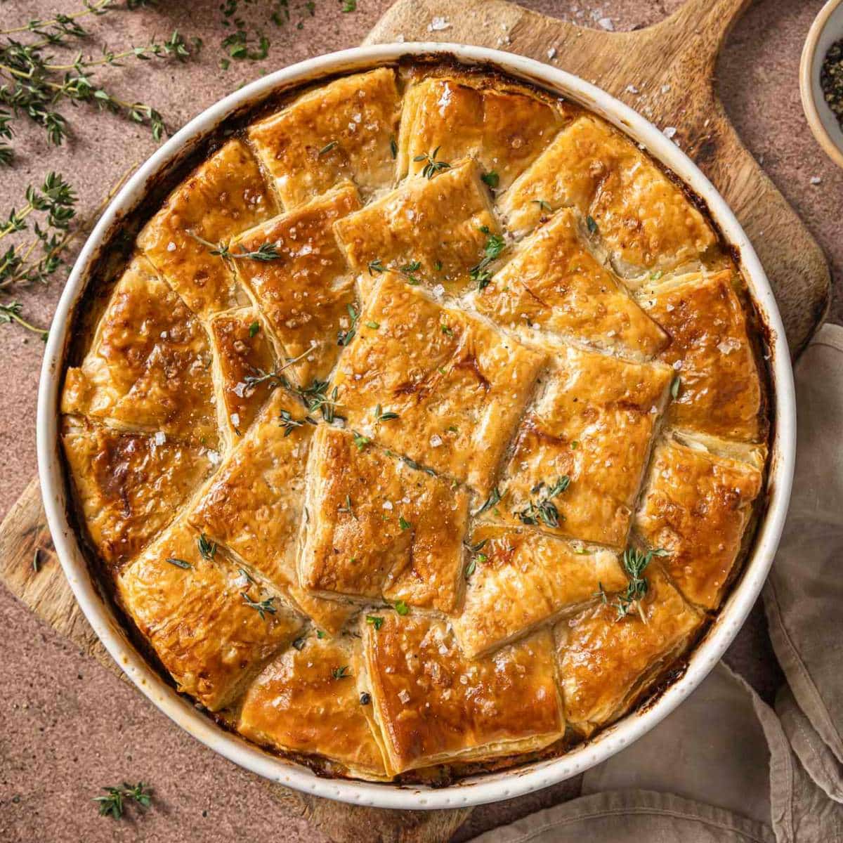 Puff pastry chicken pot pie garnished with fresh thyme.