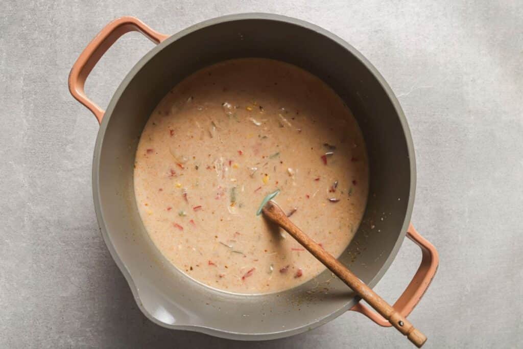 the creamy chicken fajita soup in a pot after mixing in the tempered sour cream
