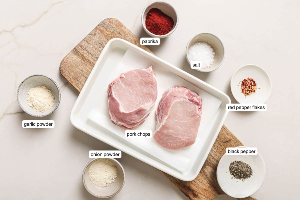 Flat lay of ingredients on a cutting board for air fryer pork chops.