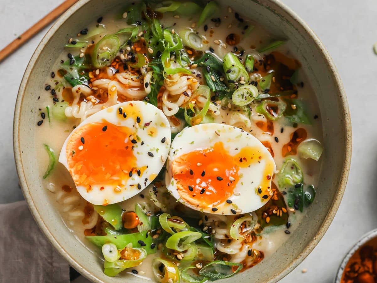 a bowl of spicy ramen topped with two jammy eggs 