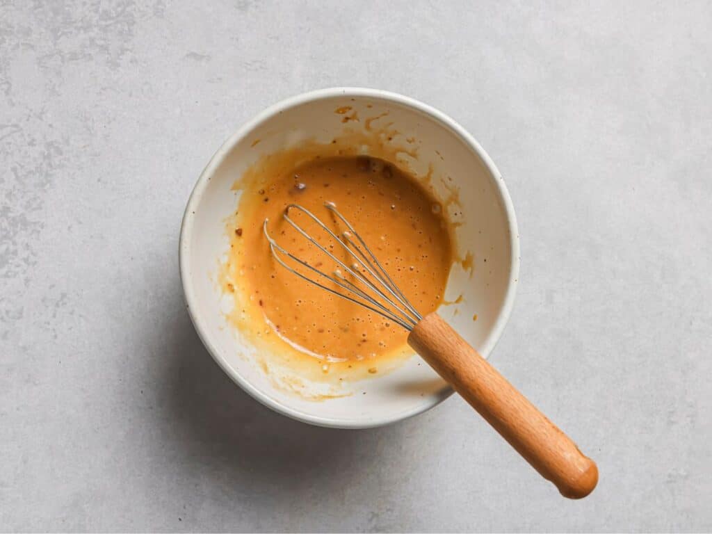 a bowl with with mayo, chili crunch, and soy sauce mixed together before adding to the spicy ramen