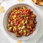 Easy avocado corn salsa with fresh tomatoes, corn, cilantro, and red onion served in a white bowl.