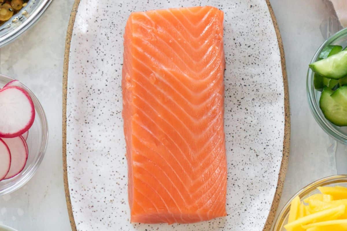 Sushi grade salmon on a white plate.