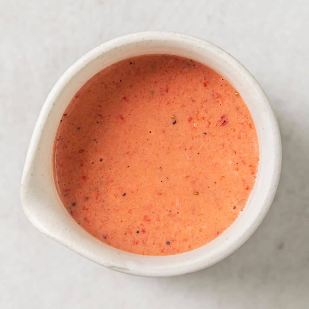a white jar filled with strawberry vinaigrette.