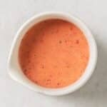 a white jar filled with strawberry vinaigrette.