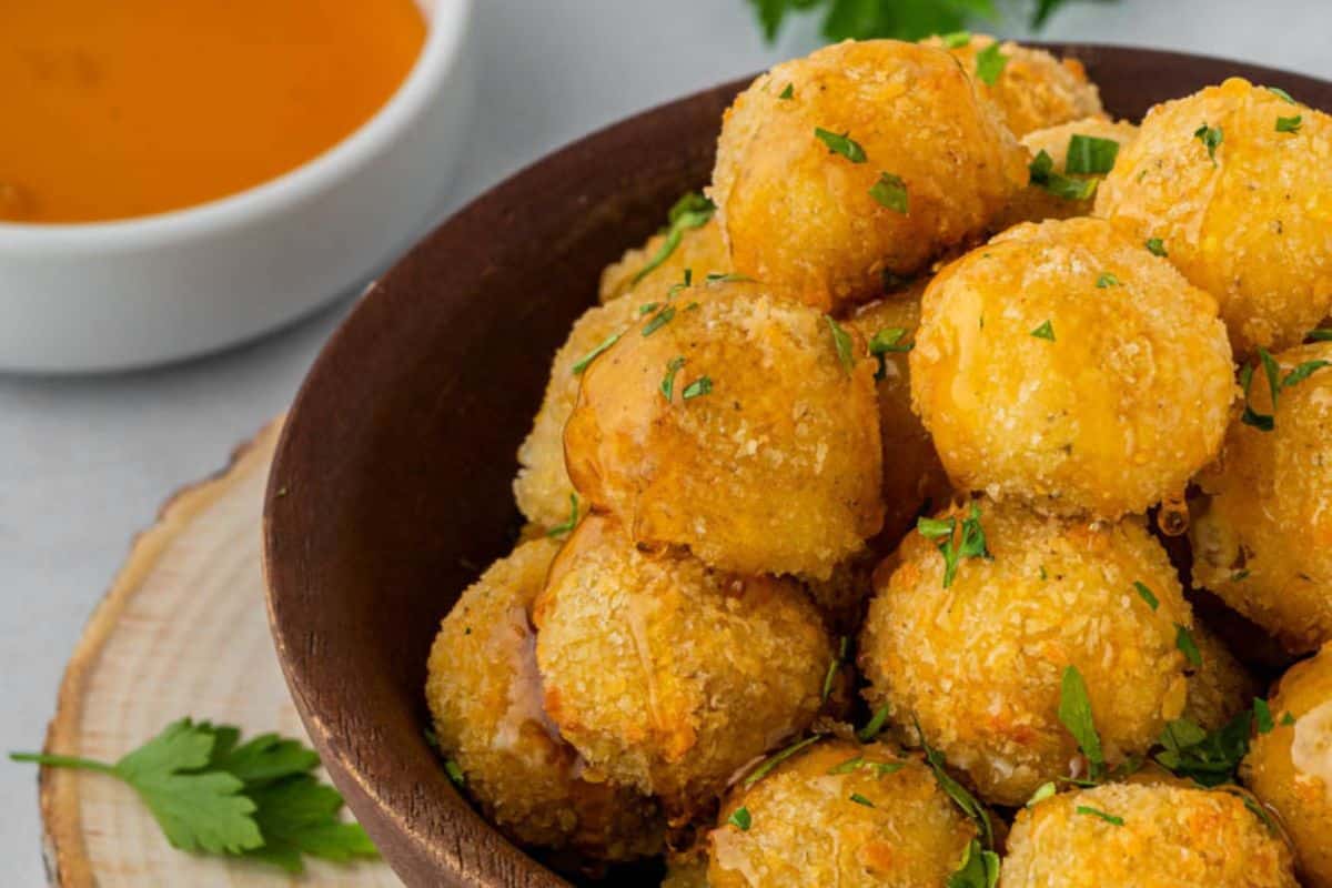 A bowl full of golden brown goat cheese bites.